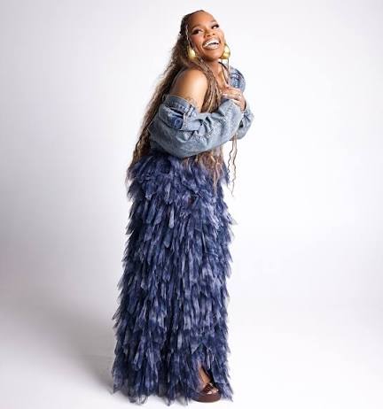 Tasha Cobbs Leonard smiling in a blue layered dress ahead of her TASHA Unscripted live album