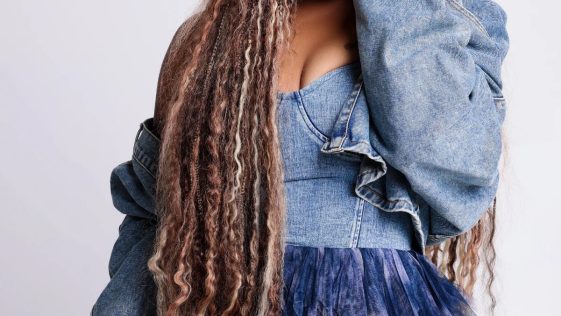 Tasha Cobbs Leonard posing in a blue denim outfit ahead of her TASHA Unscripted live album